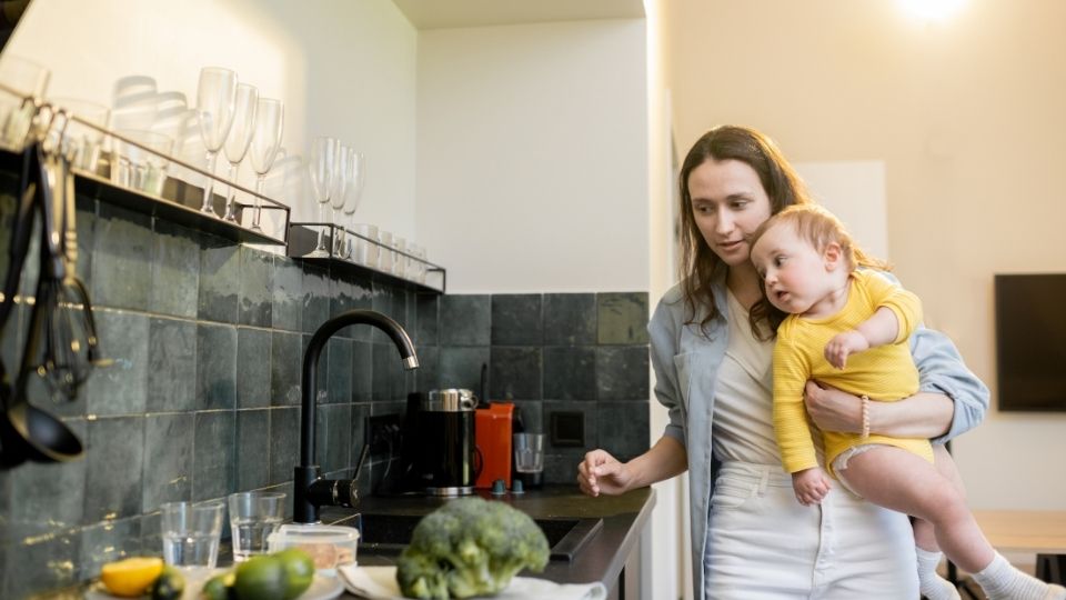 Mom Doing Chores with Baby in Hand